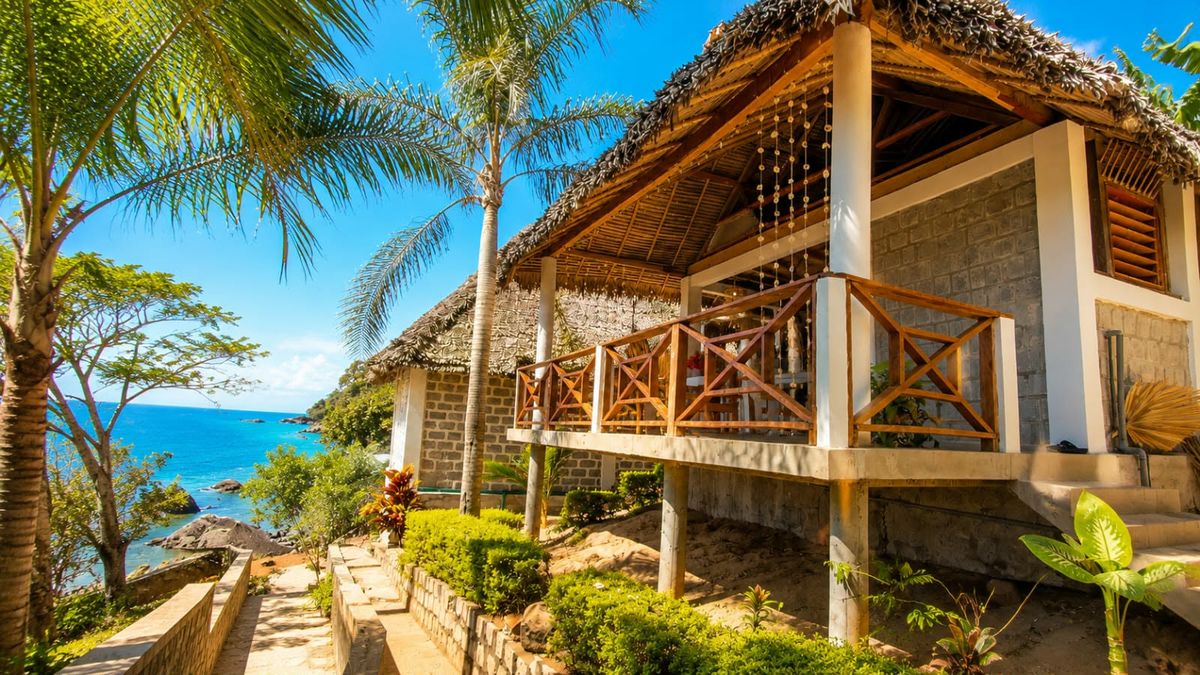 Le bungalow Soleil de Celestia, au toit de palme, entouré de palmiers