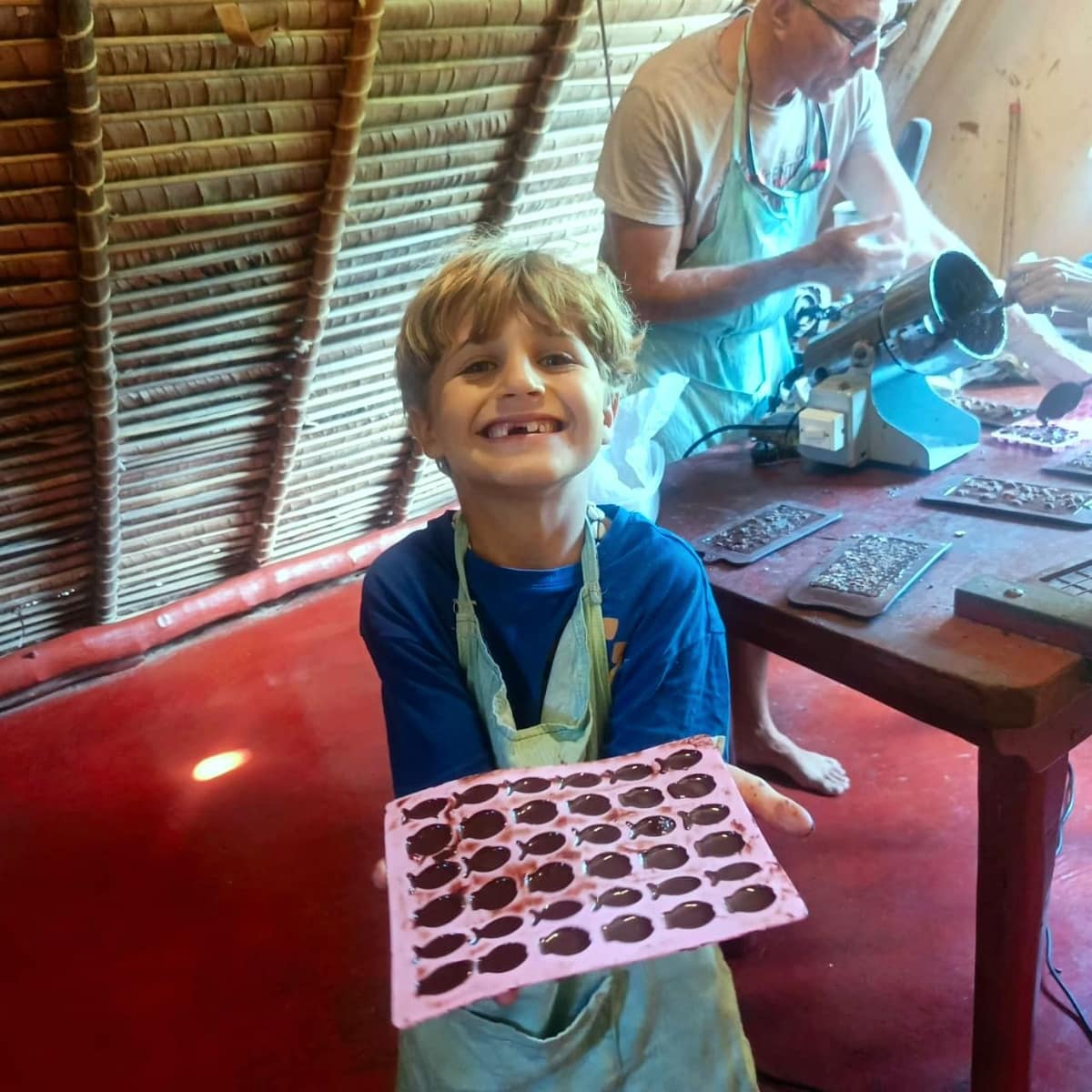 Un enfant tout sourire avec son moule à chocolat