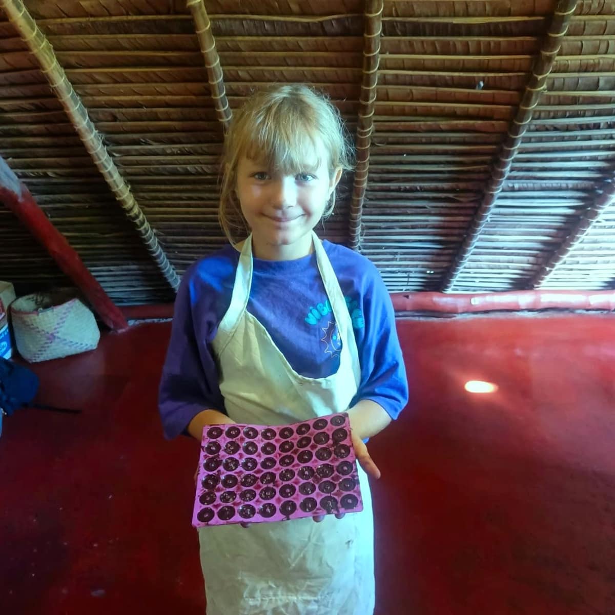 Une petite chocolatière présente son moule rempli de chocolat